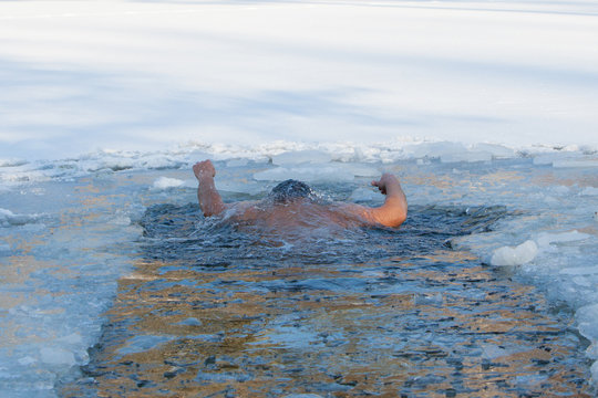Men swims invisible under water hands are up in ice hole, Drown 