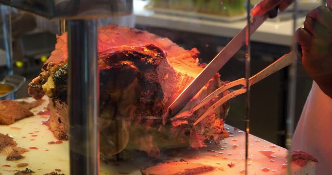 Chef slices grilled roast beef and carving prime rib at the gourmet food restaurant, 4K