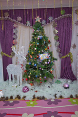 House, white deer, curtain . Winter holiday concept, decorated Christmas tree in the interior.Christmas tree star light on black background . Joyful studio shot of a Christmas tree with ornaments .