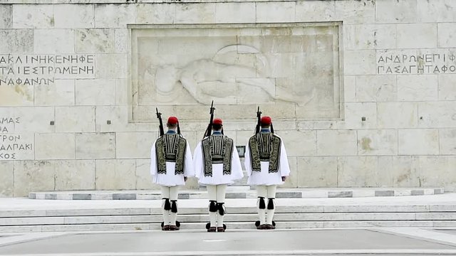 Rear view of three Honor Evzones guard in front of  the Tomb of the Unknown Soldier at the Parliament Building in Syntagma Square, Athens, Greece