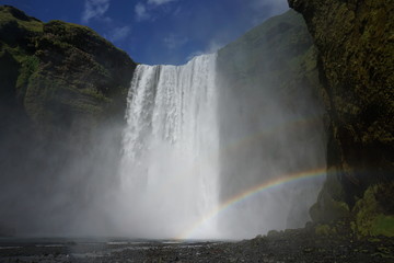 Skógafoss on Iceland in summer wih rainbow and blue sky
