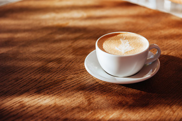 coffee cup latte art in cafe on wooden table