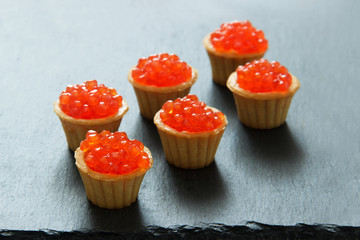 Tartlets with red caviar. Selective focus, space for text . serve red caviar