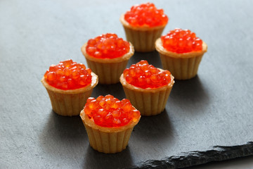 Tartlets with red caviar. Selective focus, space for text . serve red caviar