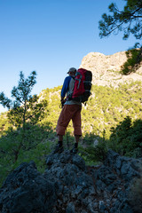 Obraz premium Traveler with backpack stands on the stone