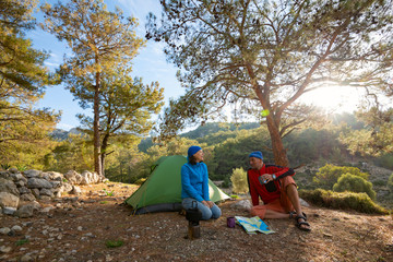 Couple of travelers is drinking coffee in the mountains