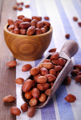 Fried peanuts in a peel in a wooden bowl on the table.