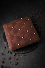 Chocolate cake in the form of a square. Assortment of confectionery.