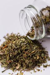 dried tarragon and essential oil on a white background