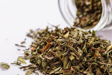 dried tarragon and essential oil on a white background