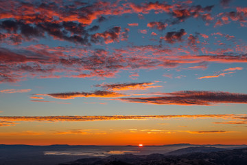 Dramatic sunset with red clouds on a blue sky background; San Francisco bay area, California