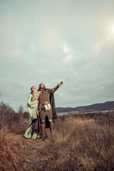 Medieval knight with lady on the sunset background.