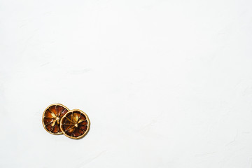 Obraz na płótnie Canvas Brown dryed orange small slice on a white marmor background