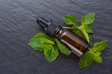 essential oil of peppermint on a dark stone background