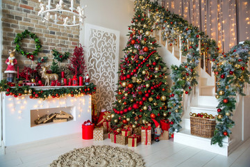 White room interior in red tones with New Year tree decorated, present boxes and artificial...