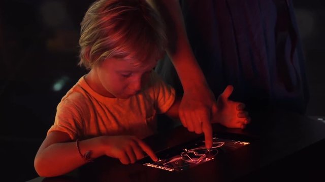 Little boy uses a table pc with an astronomical zodiak map. Children education concept.