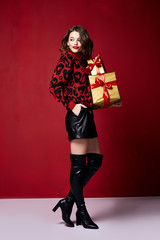 Beautiful young sexy woman thin slim body evening makeup fashionable stylish dress clothing collection, brunette, gifts boxes red silk bows holiday party birthday New Year Christmas Valentine's Day.