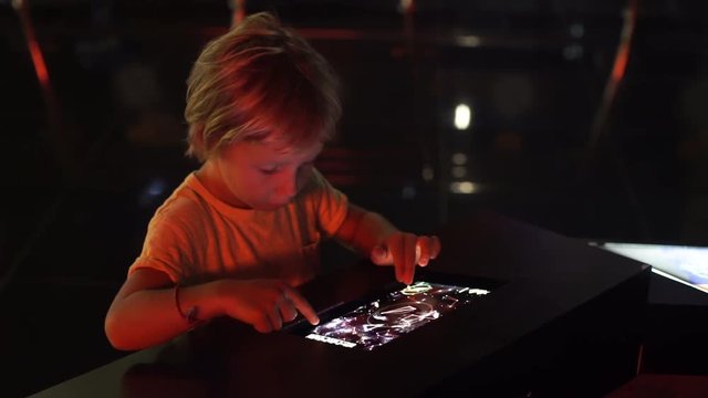 Little boy uses a table pc with an astronomical zodiak map. Children education concept.