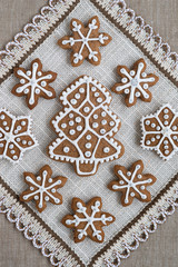 Christmas decoration on a fabric background in country style. Cookies in the shape of snowflakes, stars and fir handmade for your decoration. Top view