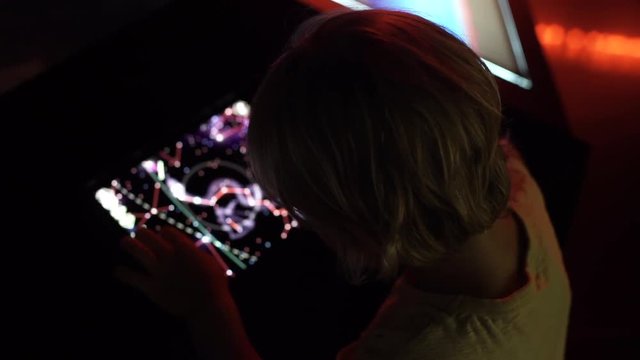 Little boy uses a table pc with an astronomical zodiak map. Children education concept.