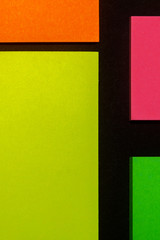 Green, yellow, orange and rose hue colorful office stickers on black paper. Office noteparer as...