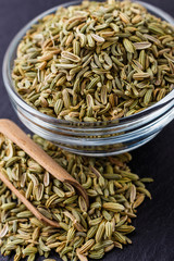 Essential oil of fennel seeds on a dark stone background