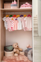 Wardrobe with cute baby clothes and toys