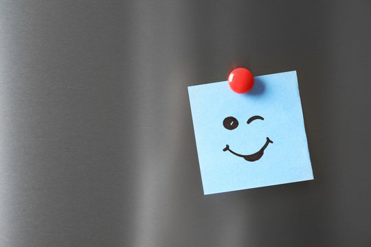 Naklejki Note with funny face on refrigerator door. Space for text