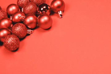 Christmas baubles on coral background.