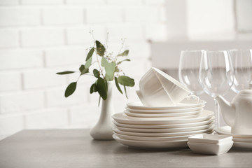 Set of clean dishes on table against blurred background. Space for text