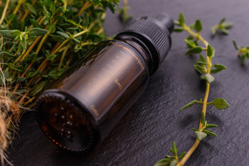 essential oil of thyme on a dark stone background