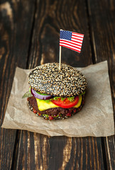 black hamburger with american flag on wooden table