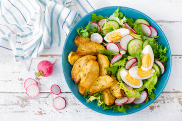 Delicious baked potato, boiled egg and fresh vegetable salad of lettuce, cucumber and radish. Summer menu for detox diet