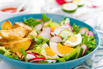 Delicious baked potato, boiled egg and fresh vegetable salad of lettuce, cucumber and radish. Summer menu for detox diet
