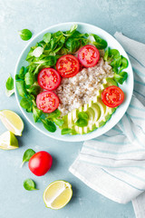 Oatmeal porridge with avocado and vegetable salad of fresh tomatoes and lettuce. Healthy dietary breakfast. Top view
