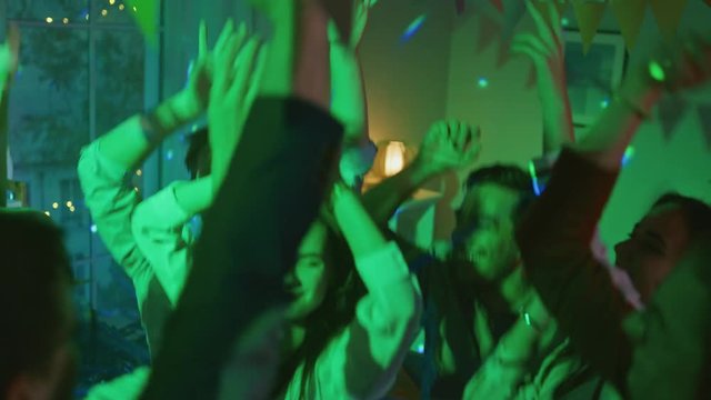 At the House Party: Diverse Group of Friends Have Fun, Dance, Jump, Socialize. Stylish Young People Clubbing. Disco Neon Lights. In Slow Motion.