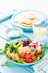 Bowl with grilled chicken meat, bulgur  and fresh vegetable salad of radish, tomatoes, avocado, kale and spinach leaves. Healthy and delicious summer lunch