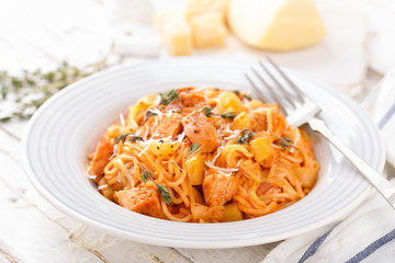 Spaghetti bolognese pasta with tomato sauce, vegetables and chicken meat on white wooden rustic background. Traditional italian food