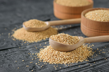 Amaranth and quinoa seeds and two wooden spoons on a wooden rustic table.