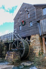 Old watermill decorated with a holiday wreath for Christmas at Historic Yates Mill County Park in Raleigh North Carolina
