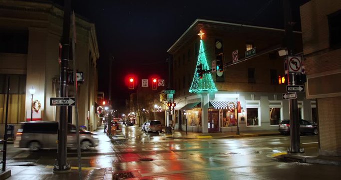A nighttime establishing shot of a typical street corner in the business district of a small town in America during Christmas season. Pittsburgh suburbs.  	