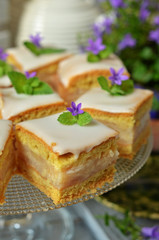 Pieces of apple cake with icing on a glass plateau
