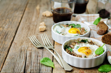 Spinach mushrooms baked egg on a wood background