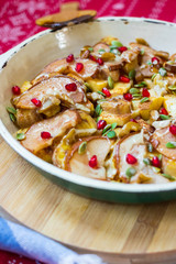 Baked fruits baked in cast iron skillet pan with apples, pears, pomegranate grains, bananas, nuts, pumpkin seeds, natural honey.