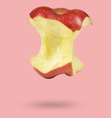 Bitten red apple isolated on pink background, minimalism.