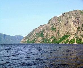 Admiring the beautiful view from the tour boat at the fjords of the Western brook pond in Gros Morne National Park, Newfoundland and Labrador, Canada