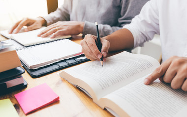 Teenage student works on homework in his room and writing in notebook.