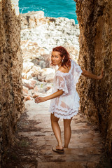 Young woman walking down a narrow rocky staircase