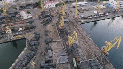 Aerial of Odessa business seaport with stacked barrels, containers and cranes