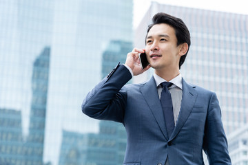 portrait of young asian business person standing in 
front of building